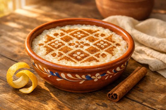 Arroz Doce — A traditional Portuguese ceramic bowl of rice pudding decorated with a delicate cinnamon pattern on a rustic table.