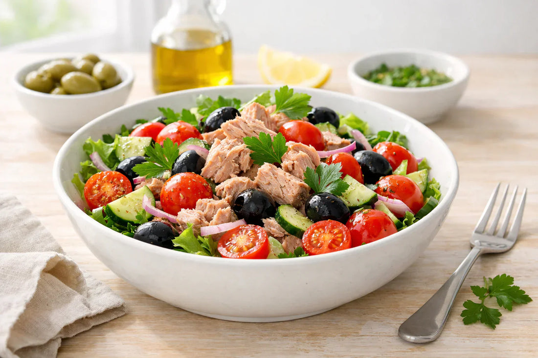 Tuna — a healthy tuna salad in a white ceramic bowl with fresh tomatoes and herbs.