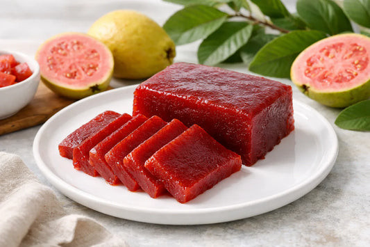 Guava paste — vibrant red goiabada slices on a plate with fresh guava fruit and leaves