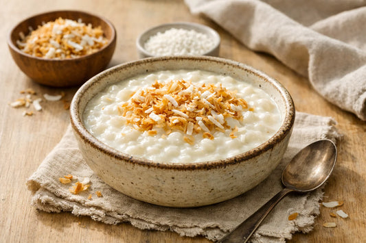 Suikervrije Tapioca Pudding — een romige, witte pudding in een keramische kom, gegarneerd met geroosterde kokos.