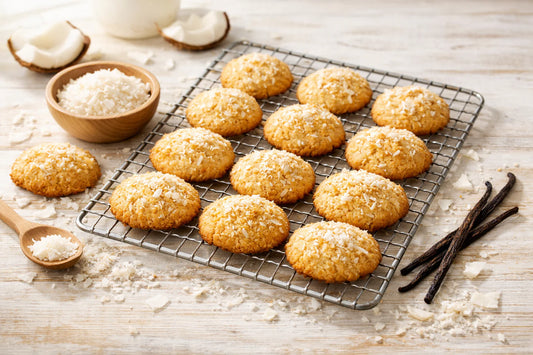 Suikervrije Kokos Koekjes — a plate of freshly baked golden-brown coconut cookies on a cooling rack.