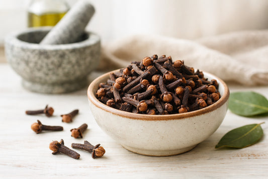 Cloves spice — whole dried cloves in a ceramic bowl with a mortar and pestle