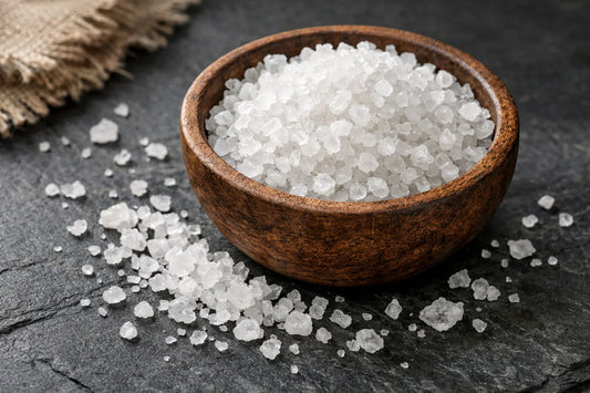 Sea Salt spice — coarse sea salt crystals in a rustic wooden bowl on a dark surface