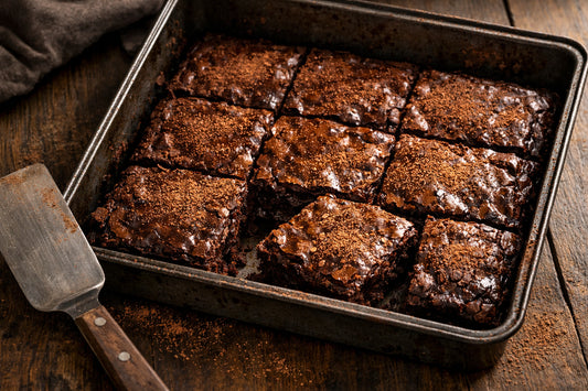 Cacaopoeder gebruikt voor het bakken van fudgy brownies, vers gesneden in een bakvorm.