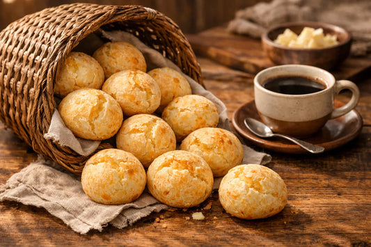 Pão de queijo kopen — a basket of freshly baked Brazilian cheese bread on a rustic wooden table.
