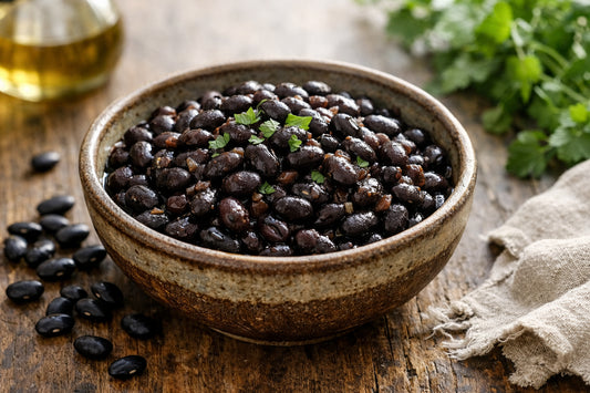 Black Bean — rustic bowl of cooked black beans with dried beans on a wooden table