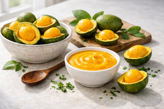 Pequi sauce — fresh golden pequi fruit and a bowl of vibrant sauce on a clean stone countertop