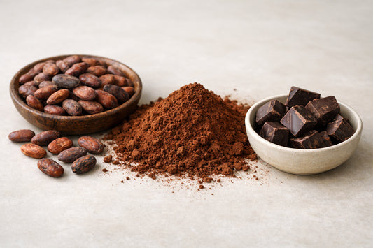 Cocoa — raw cocoa beans, cocoa powder, and dark chocolate pieces on a light surface