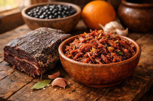 Carne Seca — raw dried beef and a bowl of shredded cooked meat on a rustic wooden table.