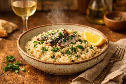 Italiaanse risotto met sardines — a close-up of a creamy risotto in a rustic bowl, topped with sardines and fresh parsley.