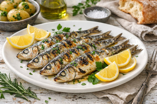Sardine — freshly grilled sardines on a plate with lemon and herbs, ready to eat.