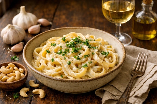 Vegan pasta — a creamy bowl of alfredo pasta garnished with fresh parsley on a rustic table.