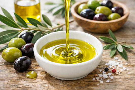 Esporaõ Azeite Virgem Extra — a close-up of golden olive oil being poured into a ceramic bowl with fresh olives nearby.