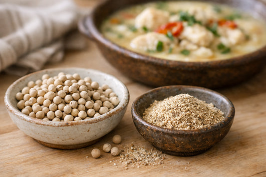 White Pepper spice — whole white peppercorns and ground white pepper in a ceramic bowl